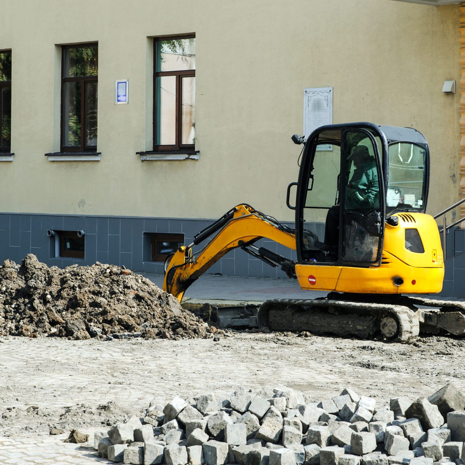 Mini excavator working on a street job site